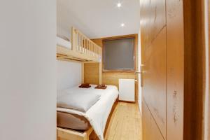 een kleine slaapkamer met een stapelbed en een trap bij Magnifique trois pieces centre Val 50m des pistes in Val dʼIsère