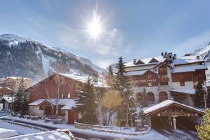 a ski lodge with snow covered buildings and a mountain at Magnifique trois pieces centre Val 50m des pistes in Val dʼIsère