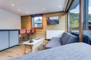 een woonkamer met een bank en een tafel bij Magnifique trois pieces centre Val 50m des pistes in Val dʼIsère