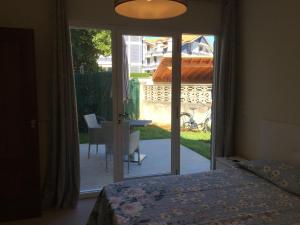 een slaapkamer met een deur naar een patio bij Casa con Jardín con 2 alojamientos, con jardines no compartidos y aparcamiento privado in Noja