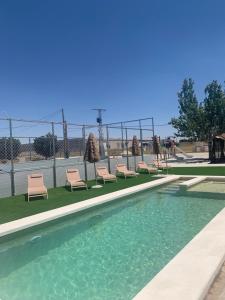 einen Pool mit Stühlen und einem Zaun in der Unterkunft Casa Rural Mi Pueblo 