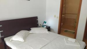 a bed with white sheets and pillows in a bedroom at Kavarna Hills in Kavarna