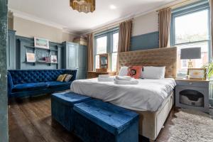 a bedroom with a large bed and a blue couch at GuestReady - A charming stay in Highgate in London