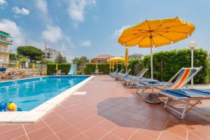 una piscina con tumbonas y sombrilla en Residence Mizar, en Pietra Ligure