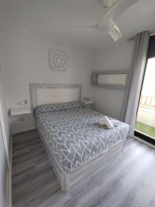 a bedroom with a bed and a large window at Ático con acceso directo al mar in Miami Platja +26 photos