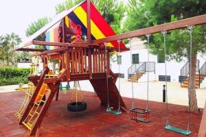 a playground with a slide and a play structure at Ático con acceso directo al mar in Miami Platja