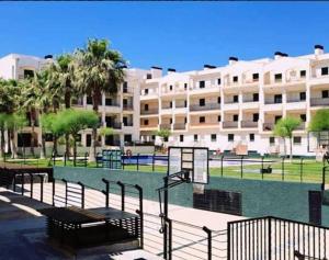 a large building with a basketball court in front of it at Ático con acceso directo al mar in Miami Platja