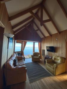 a living room with couches and a view of the ocean at Cabañas Bahia Celeste, Puerto Varas in Puerto Varas