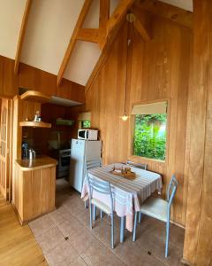 a kitchen with a table and chairs and a refrigerator at Cabañas Bahia Celeste, Puerto Varas in Puerto Varas