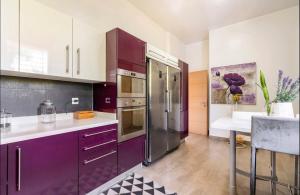 una cucina con armadietti viola e frigorifero viola di Villa Eden luxe a Bouskoura