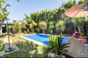 una piscina en un patio con sombrilla en Villa Eden luxe en Bouskoura