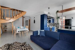 a living room with a blue couch and a table at Tjiraso Apartment in Gdańsk