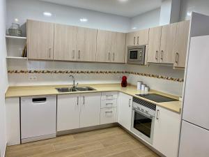 a kitchen with white cabinets and a sink at Can Blau in Les Cases d'Alcanar