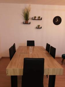 Bel appartement familial في سينون: طاولة طعام مع كراسي وساعة على الحائط