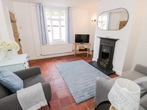a living room with a couch and a fireplace at Ross Cottage in Evesham