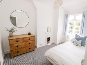 a bedroom with a bed and a mirror and a dresser at Ross Cottage in Evesham