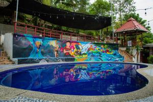 a swimming pool with a painting on the side of it at Viñas Hotel in Lanquín