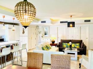 a living room with a white couch and a kitchen at Los Naranjos close to Puerto Banus in Marbella
