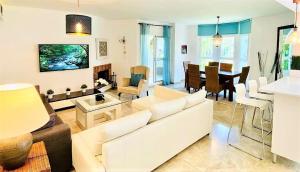 a living room with a white couch and a dining room at Los Naranjos close to Puerto Banus in Marbella