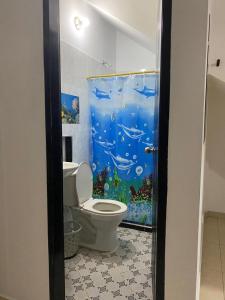 a bathroom with a toilet and an aquarium shower curtain at APARTAMENTO vista VERDE DORADAL in Doradal