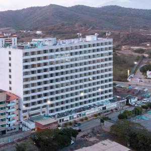 un grand bâtiment blanc avec une rue en face dans l'établissement Hotel Faranda Express Puerta del Sol Porlamar, à Porlamar