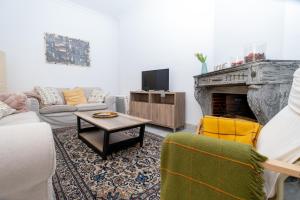 a living room with a couch and a fireplace at APARTAMENTO " A "MUSEO CASCO HISTORICO in Ronda