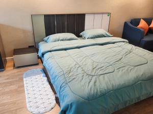 1 dormitorio con 1 cama grande y 1 silla en Baan Nonzee Condo, en Bangkok