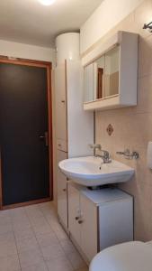 łazienka z białą umywalką i toaletą w obiekcie Casa Vacanze Boletus sul lago w mieście Claino