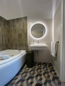 Baño blanco con bañera y lavamanos en Palazzo Lamantea Boutique Rooms, en Bisceglie