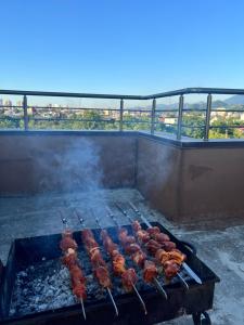 una parrilla con brochetas de carne cocinando en ella en Apartments NITA en Batumi