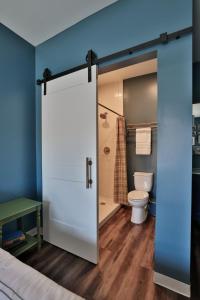 a bathroom with a toilet and a sliding glass door at Urban Collective Boutique Hotel in Edwardsville