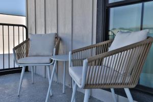 2 sillas y una mesa en el balcón en Urban Collective Boutique Hotel, en Edwardsville