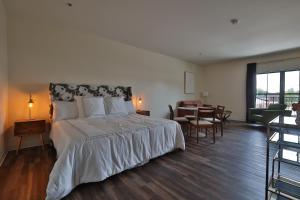 a bedroom with a large bed and a dining room at Urban Collective Boutique Hotel in Edwardsville