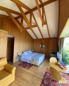 um quarto com uma cama e um sofá num quarto em Cabañas Bahia Celeste, Puerto Varas em Puerto Varas