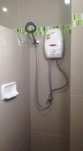 a shower in a bathroom with a blow dryer at NP Residence in Nakhon Phanom
