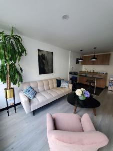sala de estar con sofá y mesa en 4 Apartaestudio Cedritos completo, en Bogotá