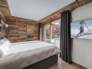 ein Schlafzimmer mit einem Bett und einem großen Fenster in der Unterkunft Chalet moderne lumineux proche pistes - 12 pers, 5 ch, parking, wifi, ménage inclus - FR-1-566-43 in Les Allues