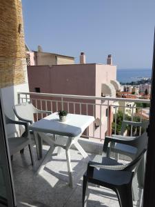 a white table and chairs on a balcony at Rafaela's Apartment in Kavala