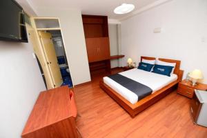 a bedroom with a bed with blue pillows at Lancelot Hostal in Chiclayo