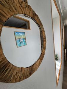 um espelho com uma moldura de madeira numa parede em APPARTEMENT COTE D'OPALE em Boulogne-sur-Mer