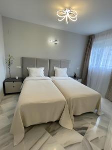 a bedroom with two beds and a ceiling fan at Luxury apartment Benalmadena First line in Benalmádena