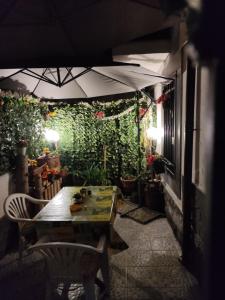 un patio con una mesa y una pared verde con plantas en Casa Da Peppe, en Catania