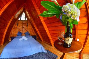 a room with a bed and a bottle of wine and flowers at CANTOS DEL VIENTO in Desamparados