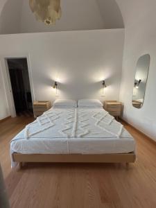 1 dormitorio con cama blanca y espejo en Palazzo Lamantea Boutique Rooms, en Bisceglie