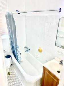 a bathroom with a tub and a toilet and a sink at Beach Block Condo in Ventnor City