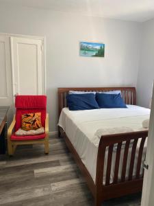 a bedroom with a bed and a red chair at Beach Block Condo in Ventnor City