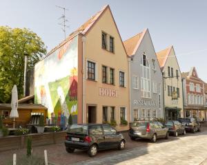 eine Straße mit Autos, die vor den Gebäuden geparkt sind in der Unterkunft Hotel Neumaier in Xanten + 33 Fotos