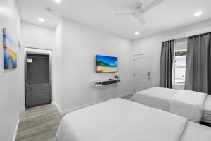 1 dormitorio blanco con 2 camas y ventana en The Hotel Deauville, en Fort Lauderdale