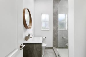 W białej łazience znajduje się umywalka i lustro. w obiekcie The Hotel Deauville w mieście Fort Lauderdale