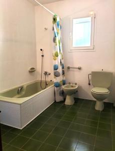 ein Badezimmer mit einer Badewanne, einem WC und einem Waschbecken in der Unterkunft Holiday Home Maria in Jávea
